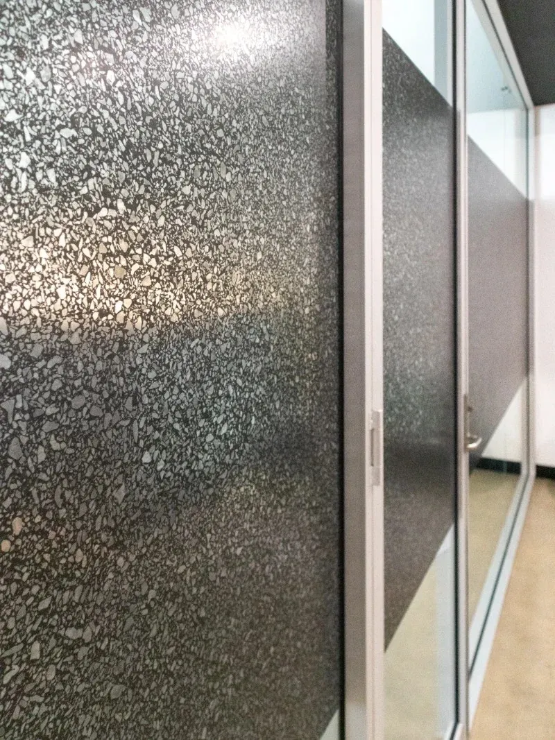 Close view of the fine flecked pattern on installed decorative glass film