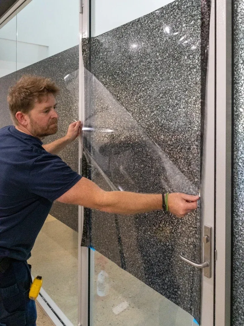 Footprint installer aligning decorative film on glass