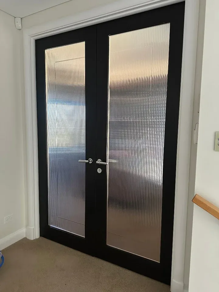 Black double doors fitted with reeded glass film