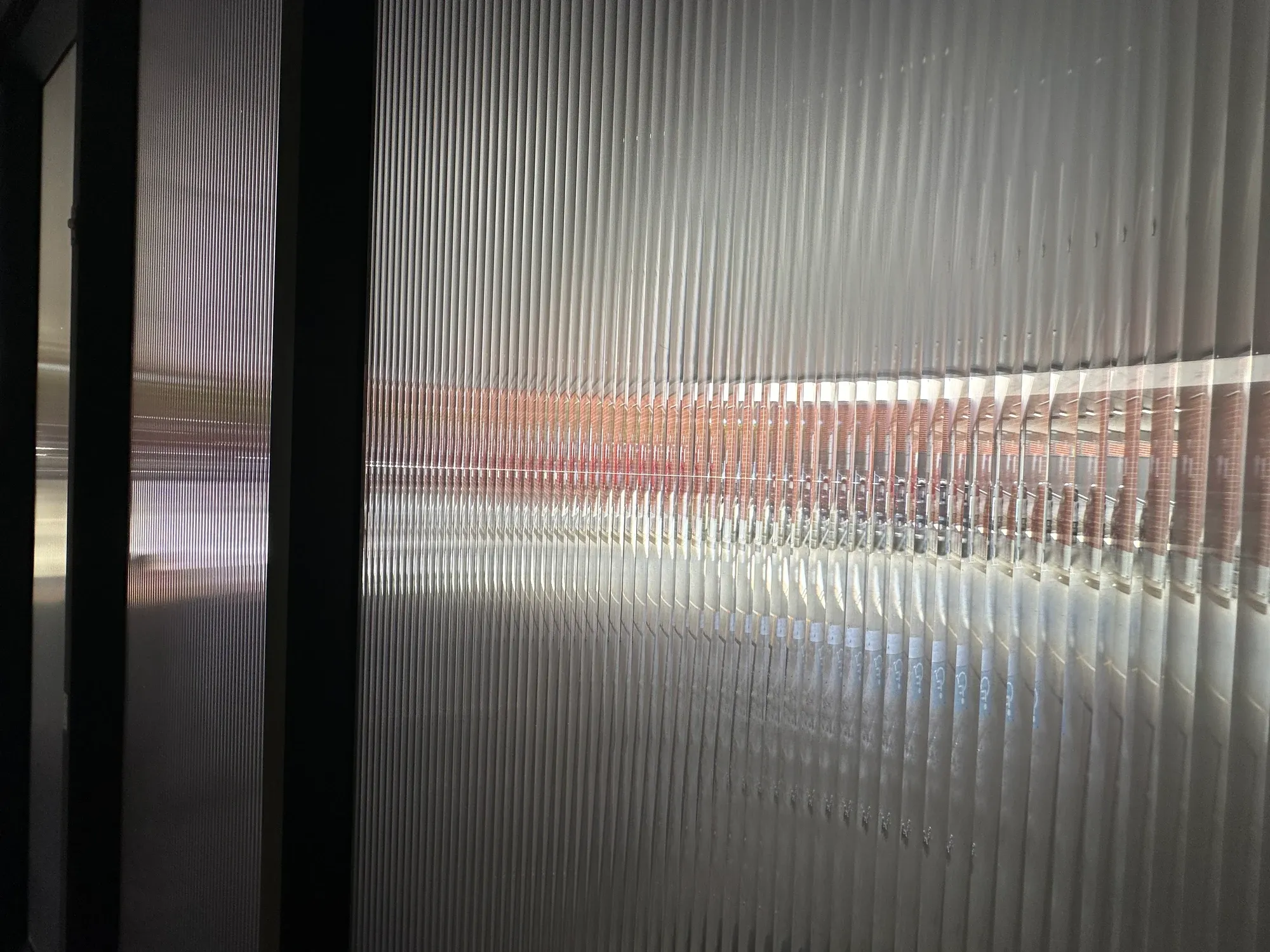 Actual smoky reeded film with crisp vertical refraction and silver highlights